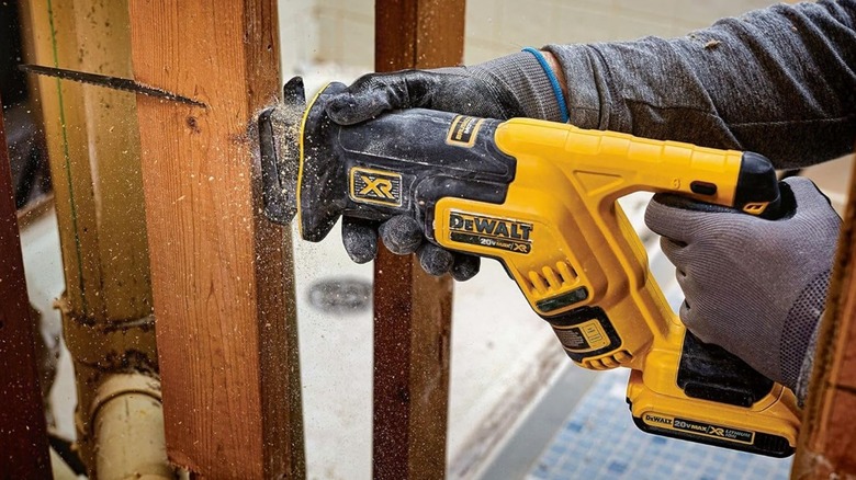 Person using DeWalt 20V Max XR Reciprocating Saw to cut 2x4
