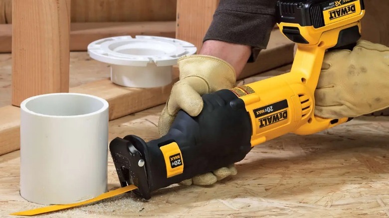 Person cutting PVS pipe with DeWalt 20V Max Reciprocating Saw