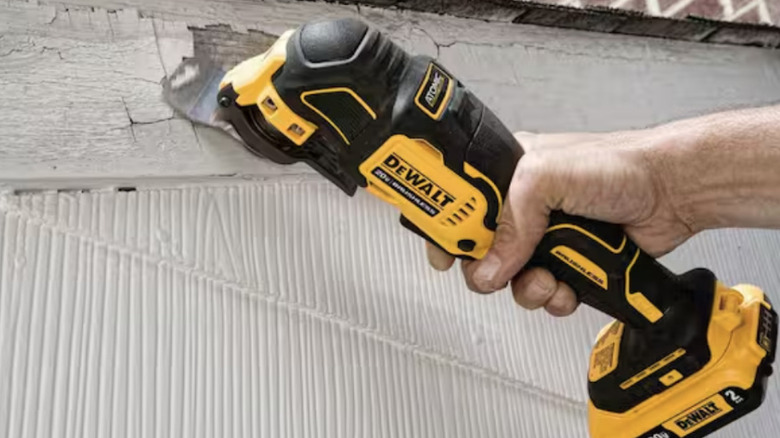 Oscillating multi-tool removing paint from old wood