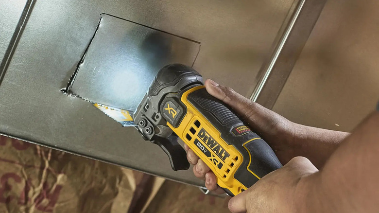 A person using a DeWalt multitool.