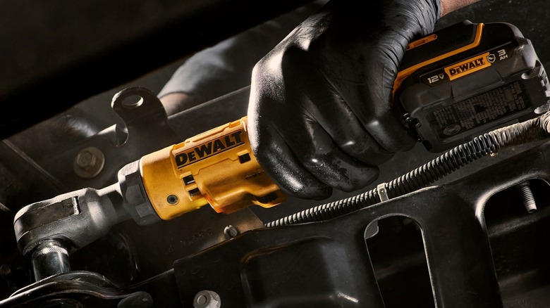 A person using a DeWalt ratchet wrench.