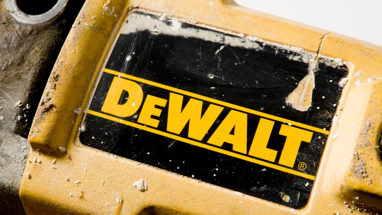 A closeup of the DeWalt logo on a heavily scratched tool.
