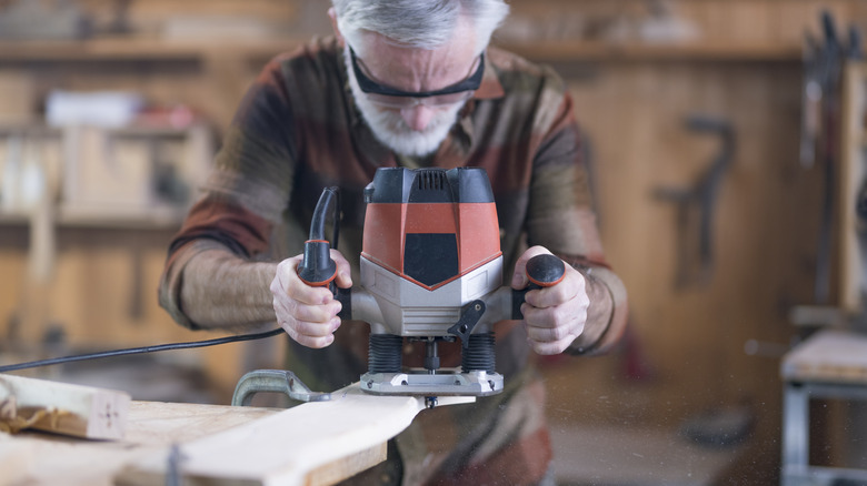 Man Using A Router On A Piece Of Wood