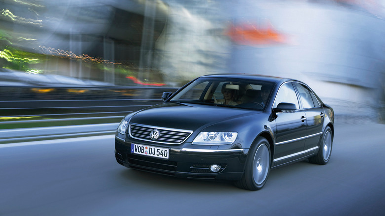 Black first-generation Volkswagen Phaeton sedan seen from front left on a city street