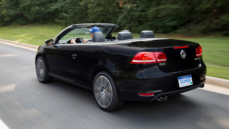 Black 2015 Volkaswagen Eos Final Edition seen from left rear driving on a road with top down