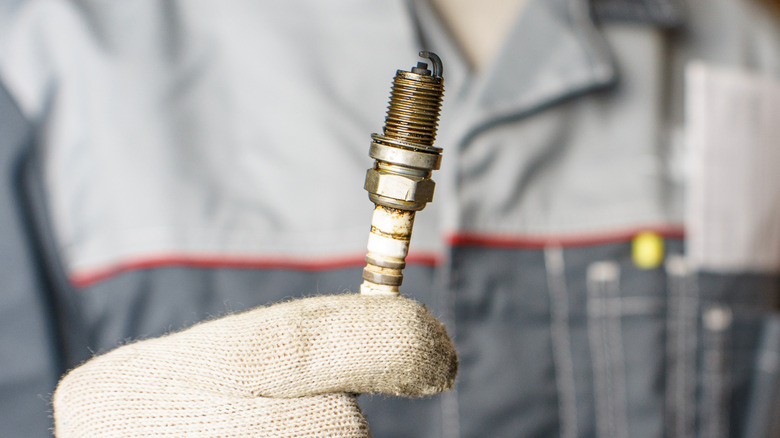 Mechanic holding used spark plug