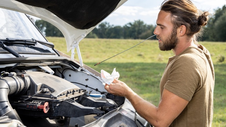 person checking engine oil level