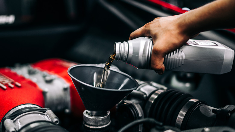 pouring oil into an engine via funnel