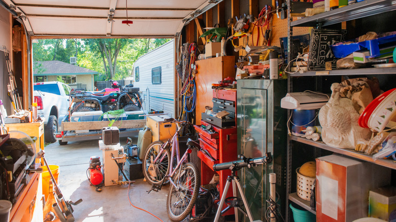 Cluttered garage with the door open