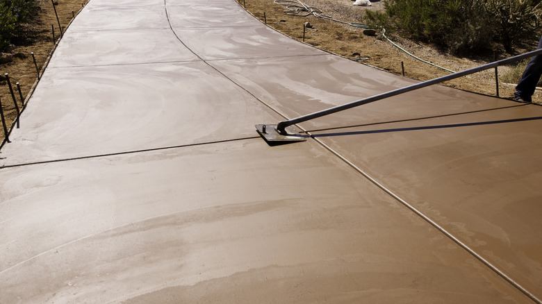 Concrete being smoothed with a long concrete placer.