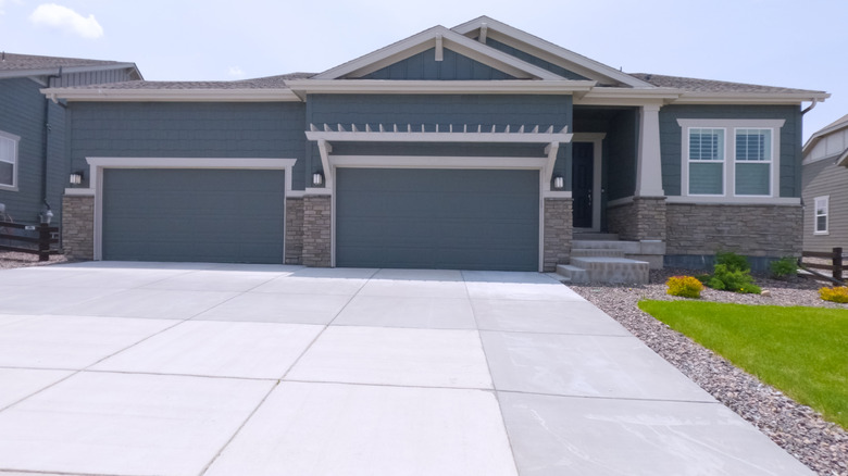 A house with a concrete driveway laid in gray and white tiles.