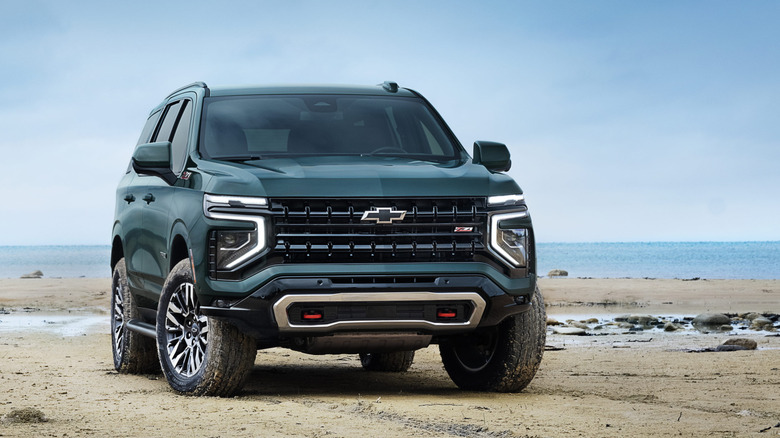 Front view of green Chevy Tahoe parked on beach.