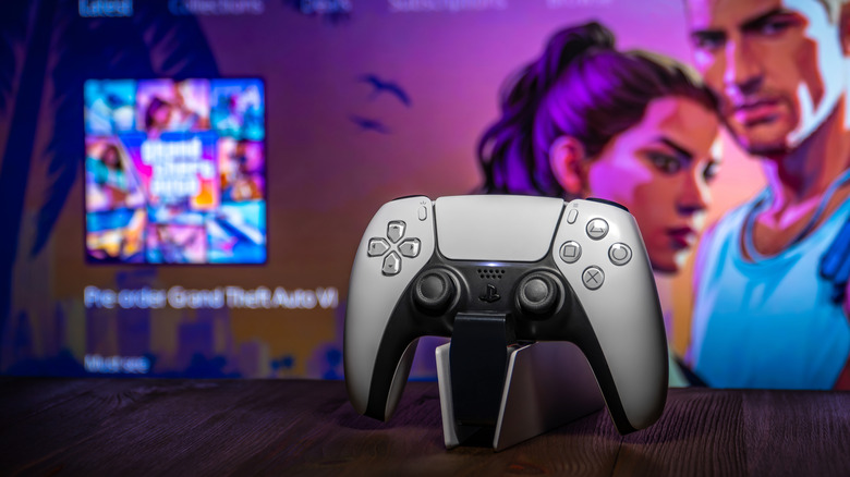 A DualSense controller in front of a splash page for GTA VI.