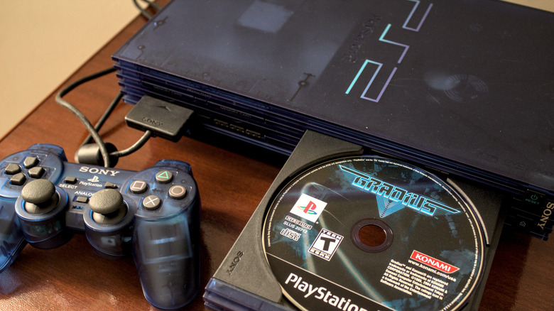 A PS2 with a blue controller and a copy of Gradius.