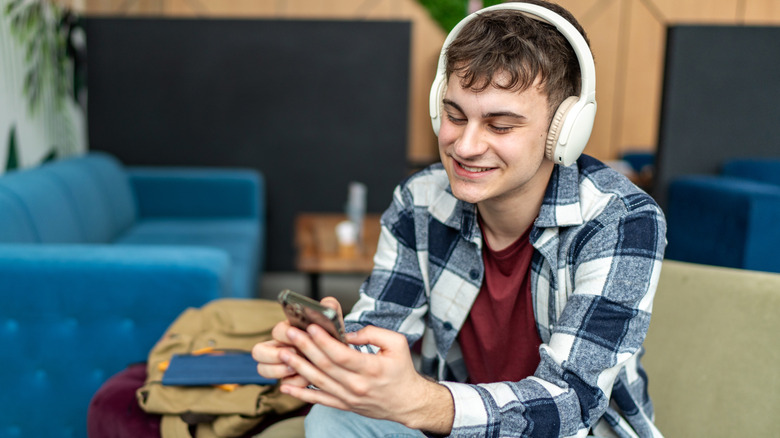 A person listening to music through wireless headphones connected to a smartphone