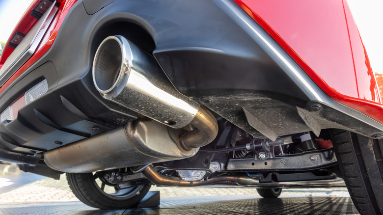 A close-up of a car's rear exhuast system and suspension.