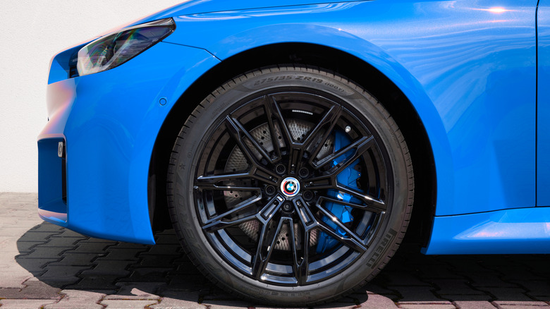 Close-up of a front wheel of a blue BMW M2 Coupe.