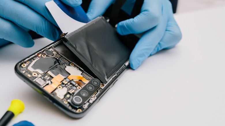 A technician in gloves repairing a phone