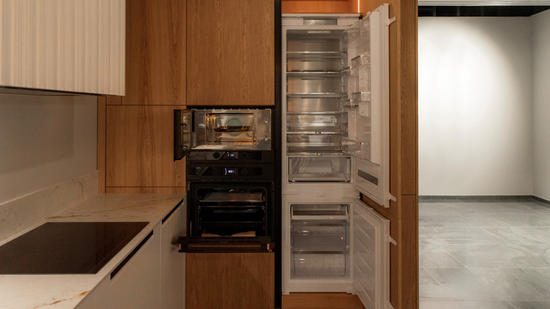 A tall built-in fridge in an empty kitchen.