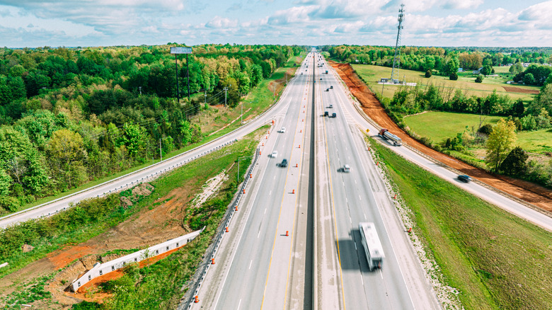 Aerial view of an American Interstate highway with light traffic in a wooded landscape