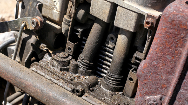 Close-up of weathered pushrod engine showing worn valvetrain components