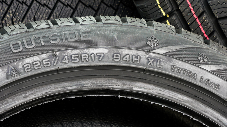 A close-up of a tire wall showing various tire markings including the 3PMSF and Snowflage symbols.