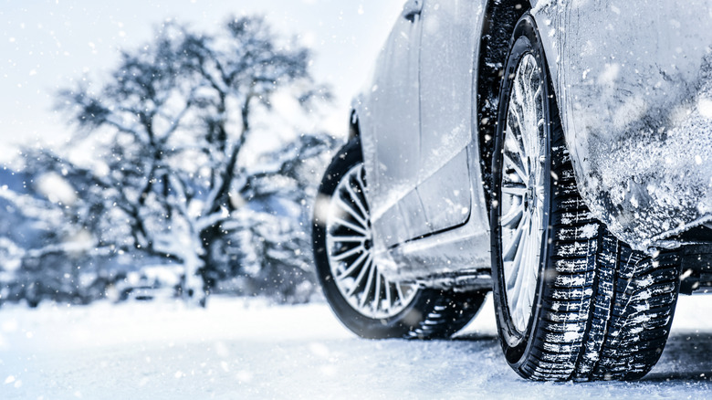 A close-up of a car's rear right tire in snow and ice.