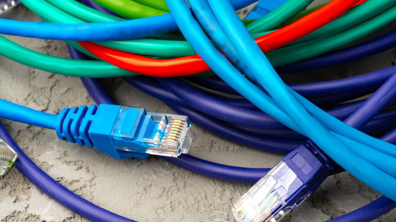 Several multi-colored ethernet cables placed on the ground