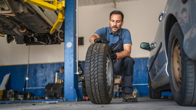 A mechanic rotating a car's tires