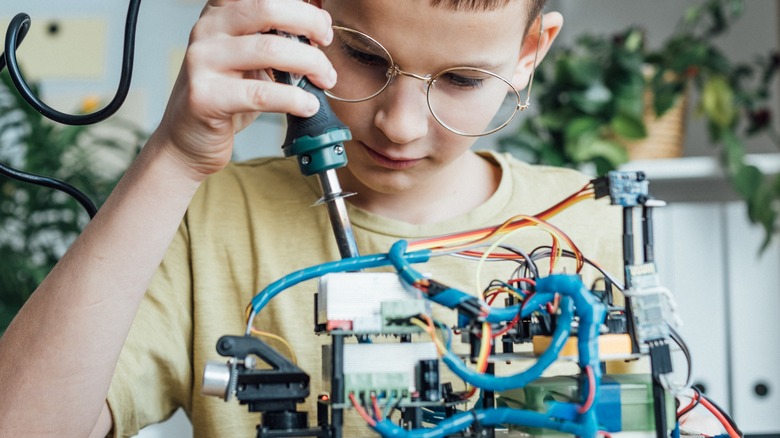 kid soldering on mobile robot