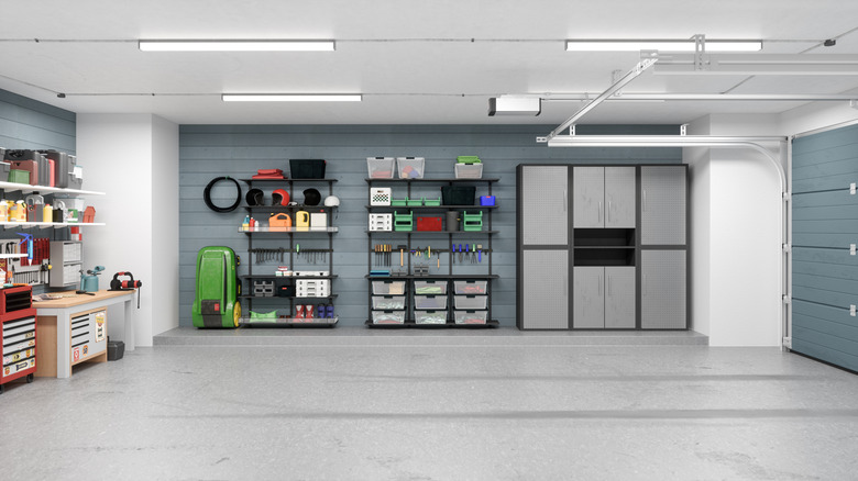Interior of home garage showing two walls of storage units and tools