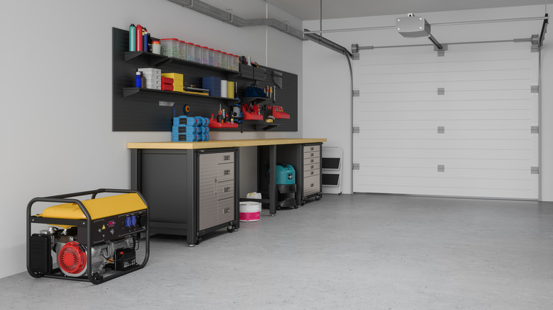 Interior of home garage with a wall of storage cabinets and tools