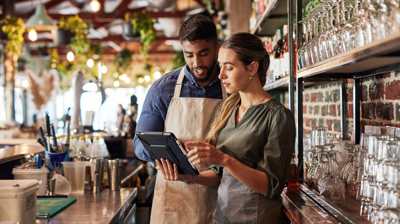 Two small business owners look at an iPad