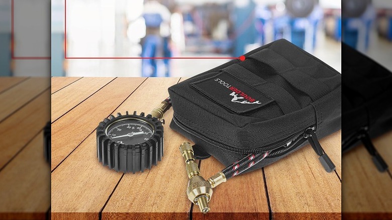Tire deflator with a carrying bag placed on a wooden table.