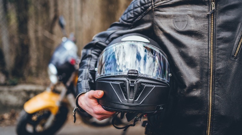 Person holding helmet in arms 
