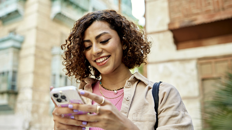 woman smiling using iPhone