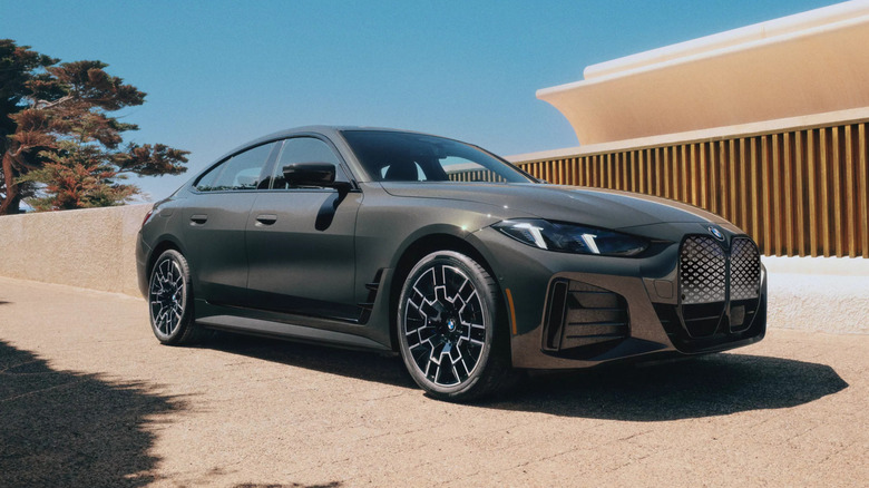 A 2026 BMW i4 coupe parked beside a fence.