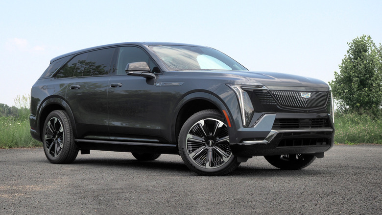 Black Cadillac Escalade iQ parked on asphalt in a rural setting