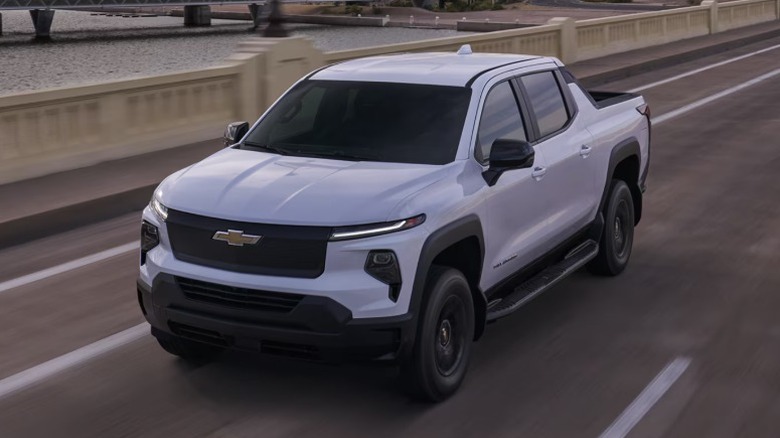 White Chevrolet Silverado EV Work Truck driving over a bridge