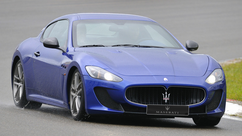 A blue Maserati Gran Turismo being driven on a track.