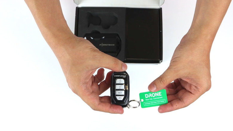 A person holding the remote for the Compustar remote starter kit