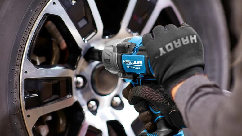 man using drill on wheel