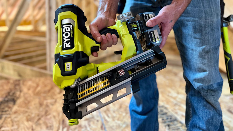 Worker fits battery to a Ryobi 18V One+ framing nailer