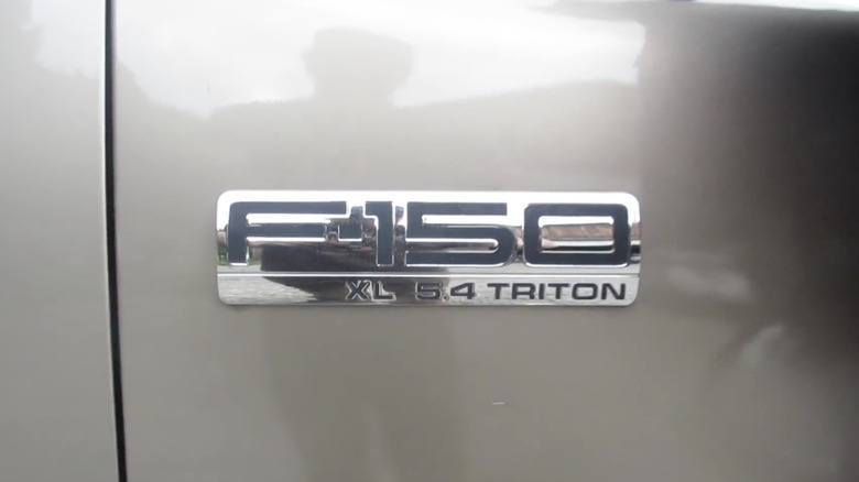 A close-up of a Ford F-150 XL 5.4 Triton engine badge.