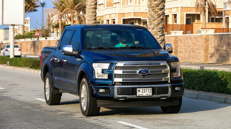 A dark blue 2018 Ford F-150 being driven in sunny Dubai.