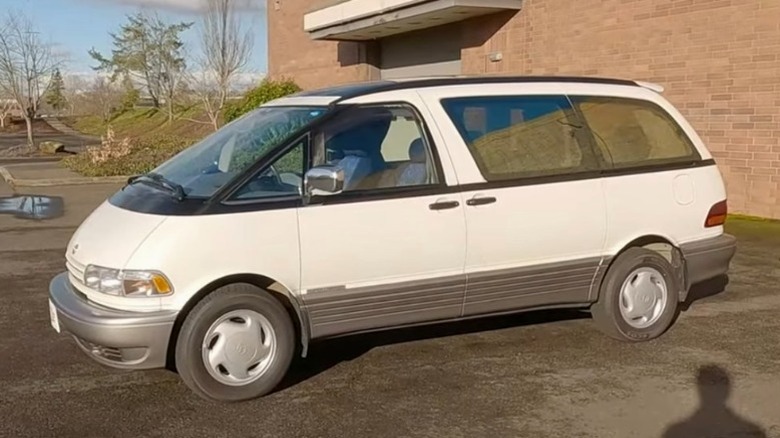 White Toyota Previa parked in front of a red brick building