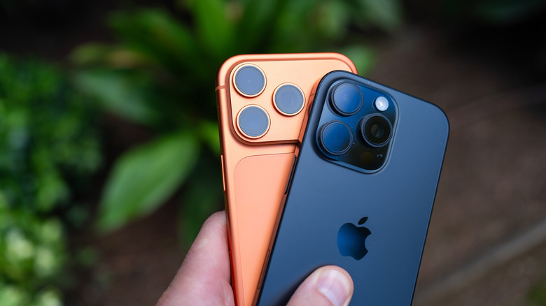 A person holding a couple of iPhones