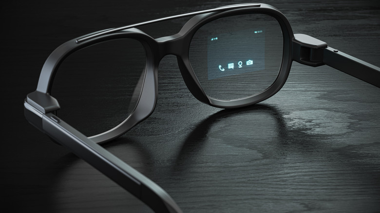A pair of smart glasses on a dark surface.