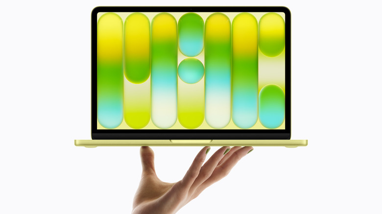 A hand holding up the MacBook Neo over a white background