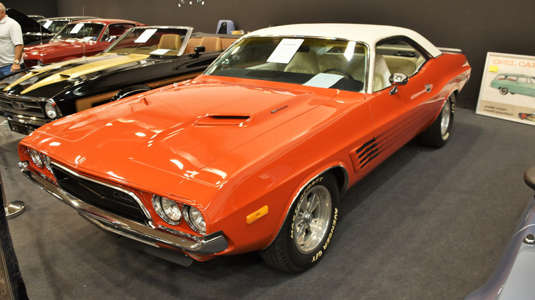 A bright orange 1973 Dodge Challenger on a showroom floor